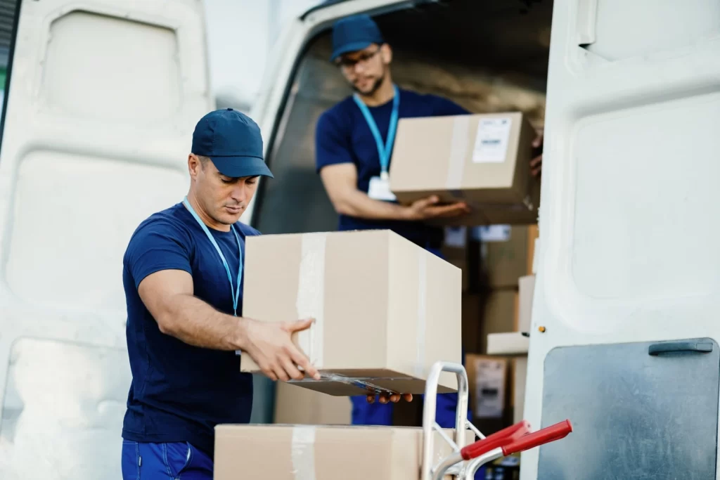 Mudanzas comerciales; Dos hombres descargando cajas de un camión