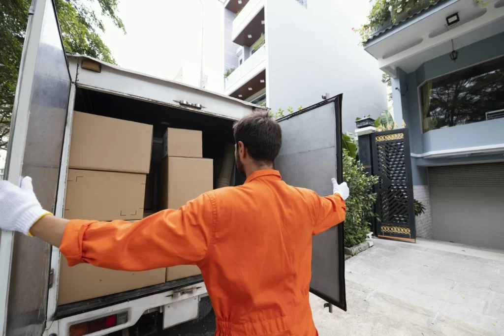 Mudanzas residenciales; Hombre cerrando puertas de la furgoneta que transporta las cajas