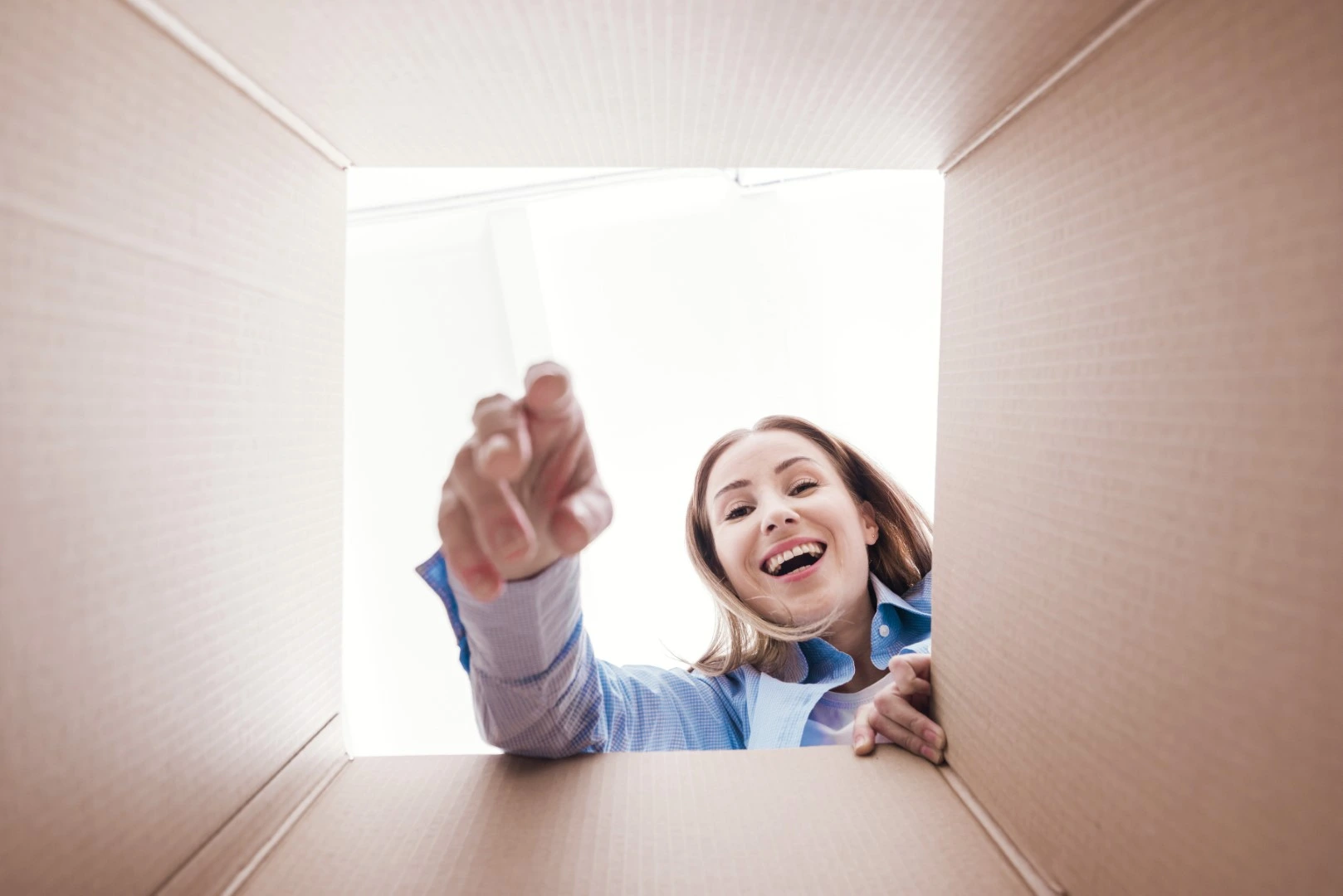 Fletes en Guadalajara; Mujer feliz sacando cosas en el fondo de una caja
                