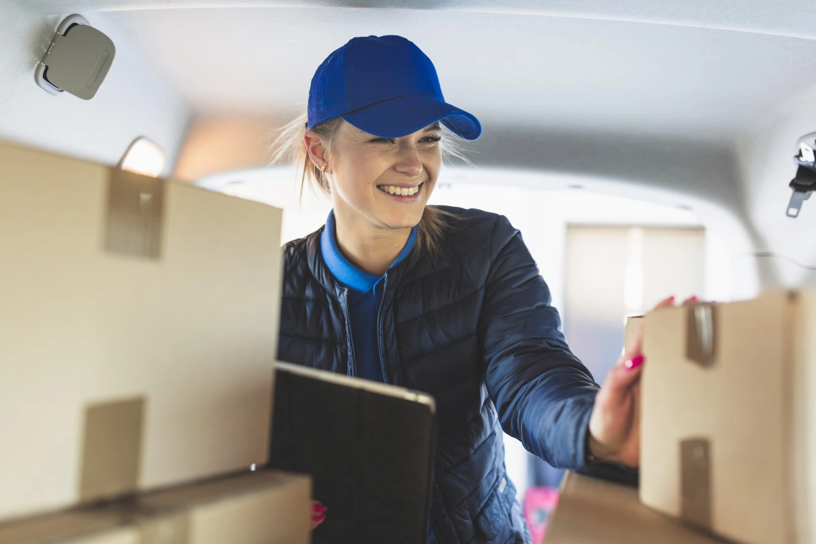 Servicio de fletes; Mujer feliz haciendo chequeo de mercancía de mudanzas 
          Servicio de fletes; Mujer feliz haciendo chequeo de mercancía de mudanzas