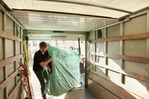 Servicio de mudanzas; Personas subiendo artículos voluminosos a una camioneta de mudanza