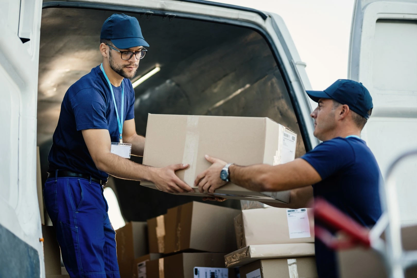 Fletes y mudanzas en Guadalajara; Par de hombres vestidos de uniforme azul subiendo cosas a un camión de mudanzas 