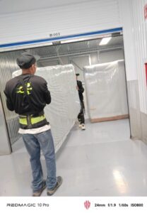 Dos hombres con faja realizando un costo de mudanzas.